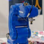 A blue Yaskawa industrial robot arm on display, showcasing advanced technology and robotics.