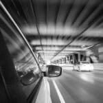 Black and white motion blur shot from a car on a San Francisco bridge at night.