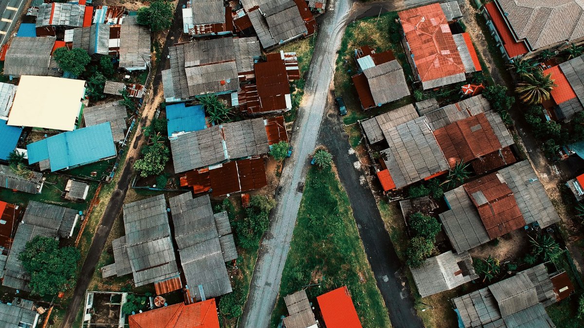 Aerial view of an urban neighborhood showing roads and colorful rooftops.