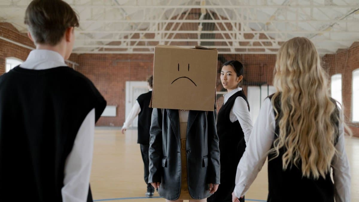 Students in a school gym highlighting themes of bullying and peer pressure.