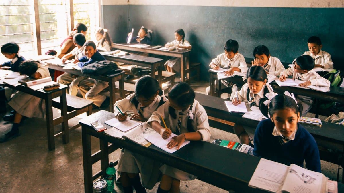Elementary school children studying in a classroom, focusing intently on their work.