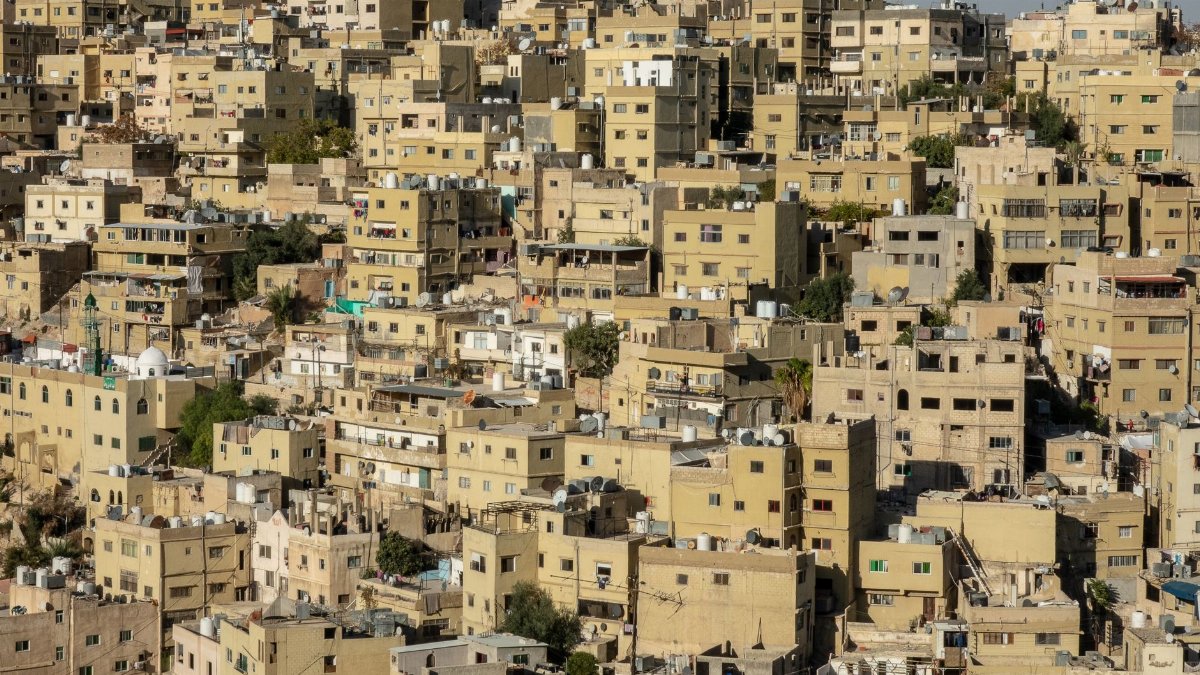 Explore a densely packed residential area with yellow buildings under clear daylight, capturing urban density and architecture.