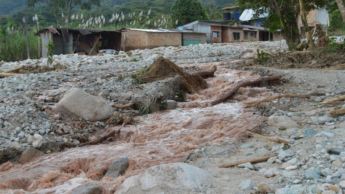 Aftermath of a flood in rural Mocoa, Colombia, showing debris and destruction.
