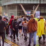 A large group peacefully protests for trans rights in a city, advocating equality.