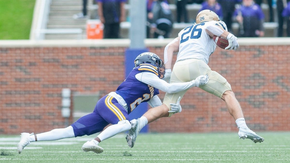 Action-packed capture of a dramatic tackle in an American football game, showcasing athletic skill.