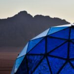 Geodesic blue dome in Wadi Rum desert with stunning mountain backdrop, perfect for luxury glamping.