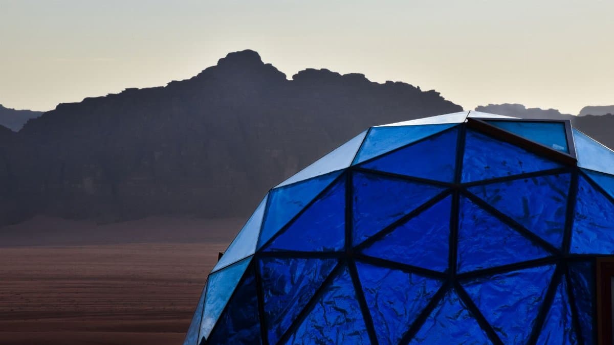 Geodesic blue dome in Wadi Rum desert with stunning mountain backdrop, perfect for luxury glamping.