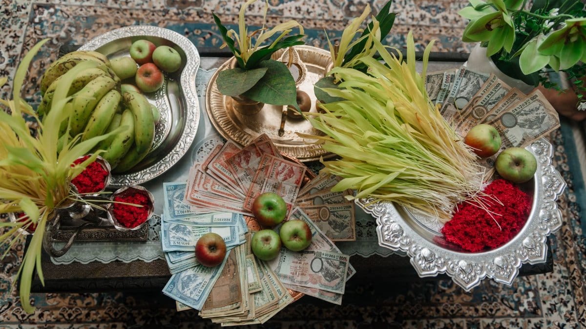 Top view of traditional Dashain offerings with fruits, money, and cultural elements on a table.