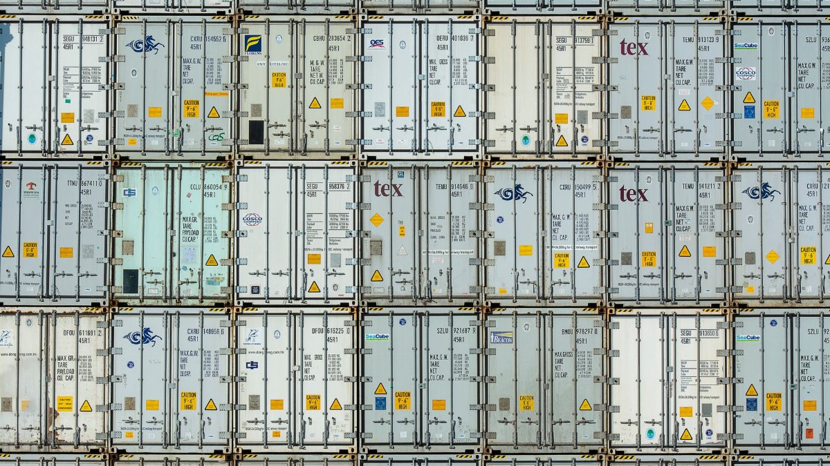 A patterned array of industrial shipping containers stacked in a storage terminal.