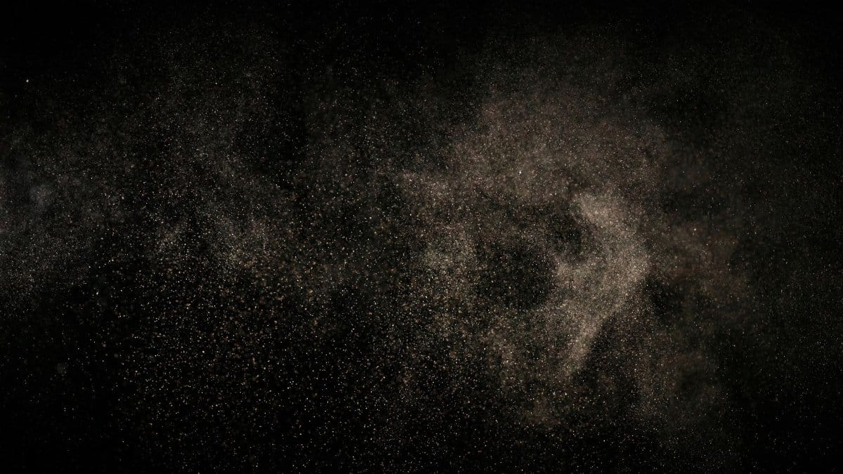 Abstract image of fine particles floating against a black background.