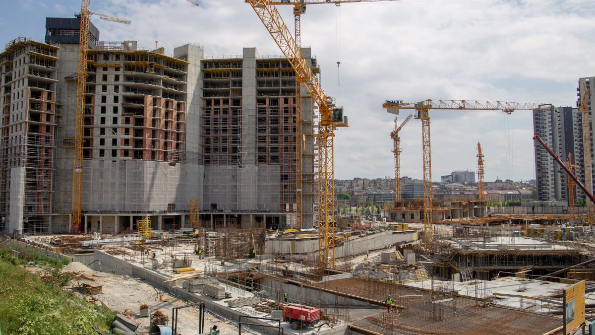 View of a bustling urban construction site with cranes and high-rise buildings.