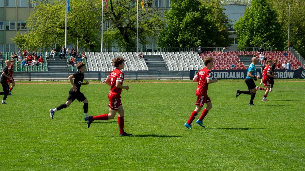 Players competing in a youth soccer match at a stadium in Wrocław, Poland.