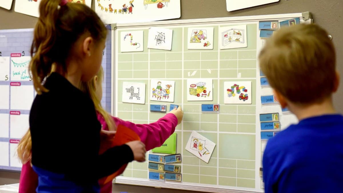 Children in a classroom interact with an educational board to enhance learning and teamwork.