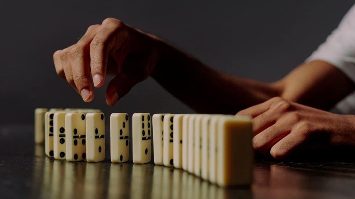A detailed shot of hands placing dominoes in a row, symbolizing strategy and precision.