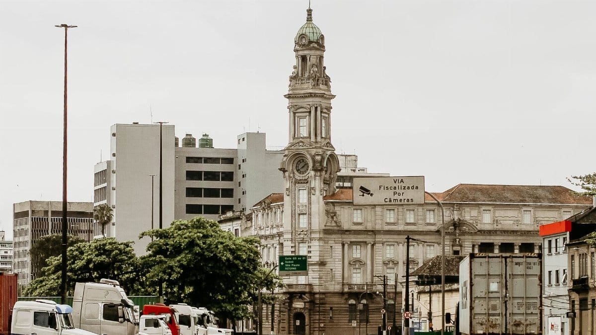A historic tower surrounded by urban buildings and street traffic in a city setting.