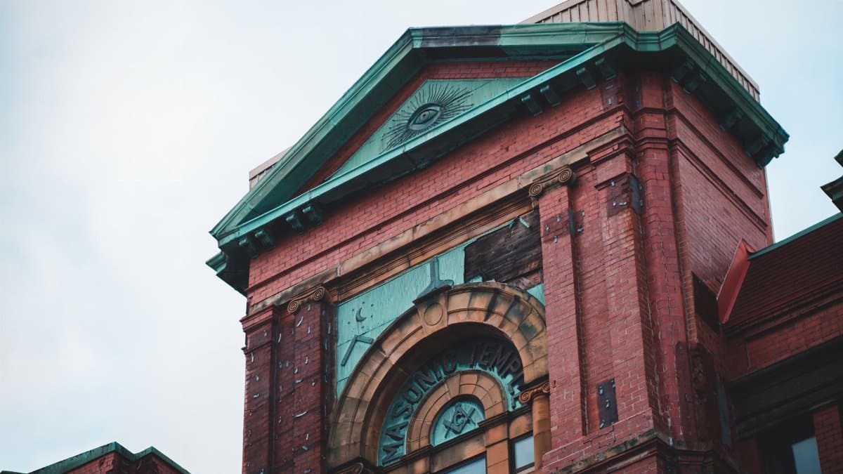 Low angle view of a historic brick Masonic Temple with ornate architectural details.