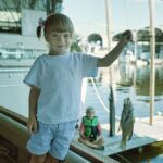 A child proudly displays her catch while fishing at a marina in Wabasha, Minnesota.