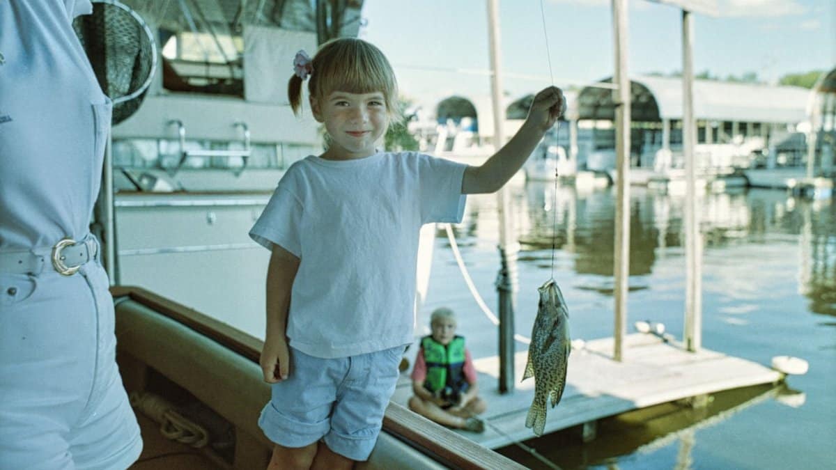 A child proudly displays her catch while fishing at a marina in Wabasha, Minnesota.
