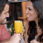 Happy couple toasting with mimosas at a Miami Beach cafe. Perfect for lifestyle and travel themes.