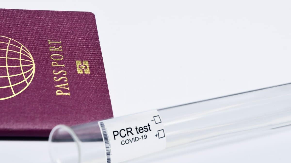 Close-up of a passport and PCR test for COVID-19 depicting travel and health safety measures.