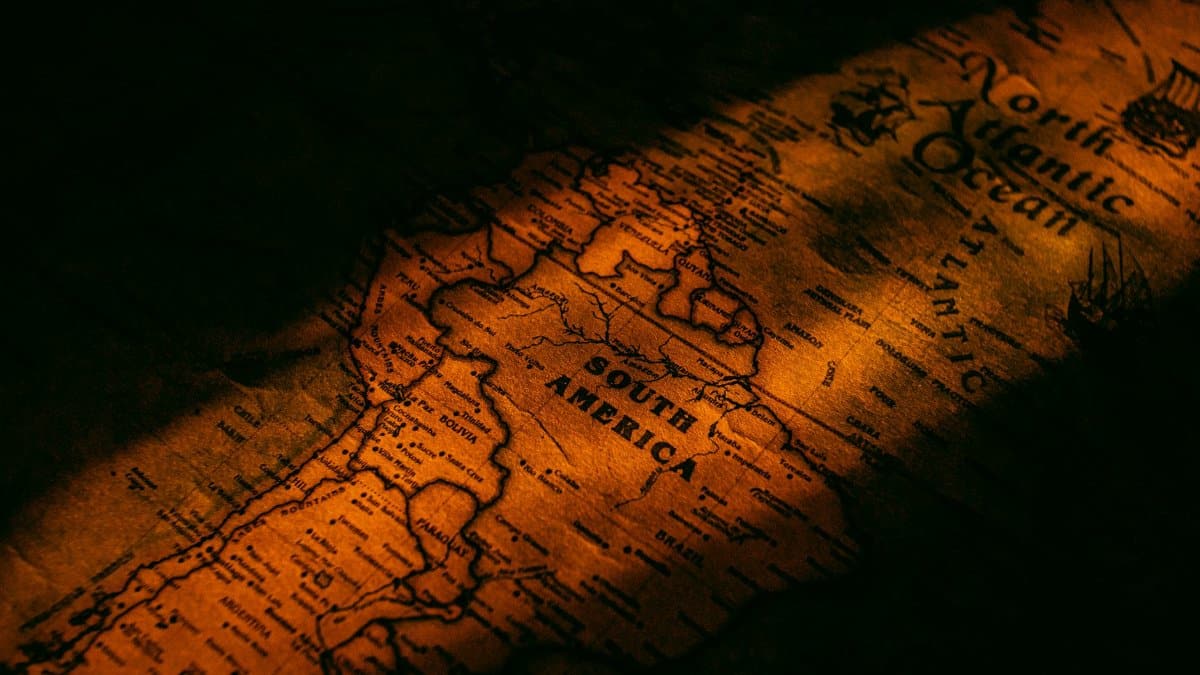 Close-up vintage map of South America illuminated by warm, artistic lighting giving a historical feel.
