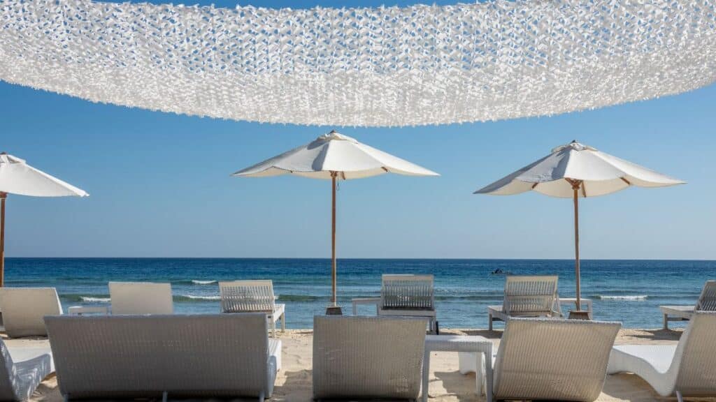 Tranquil beach scene with lounge chairs and umbrellas by the ocean.