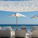 Tranquil beach scene with lounge chairs and umbrellas by the ocean.