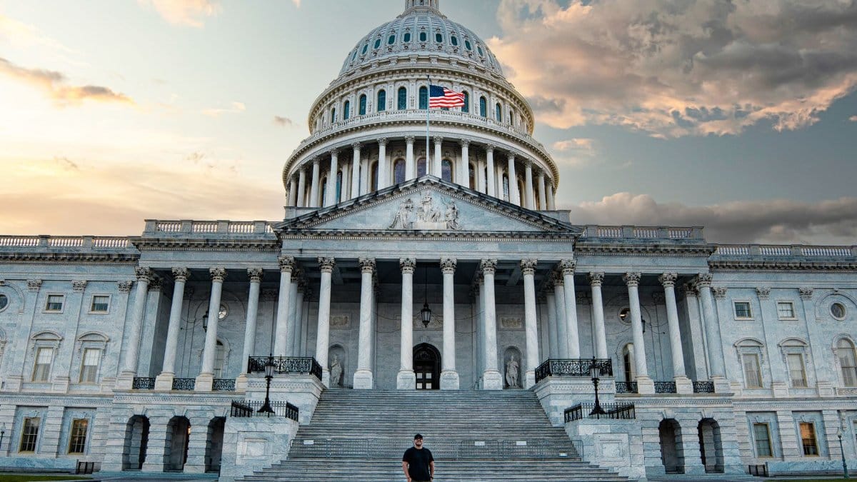 Front view of the iconic United States Capitol with dramatic evening sky.