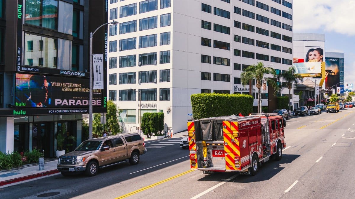Los Angeles fire truck cruising down the famous Sunset Strip in daylight.