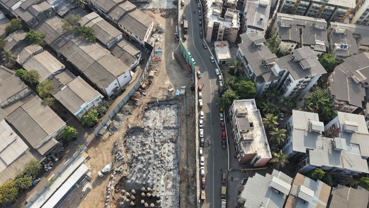 Aerial view of construction site amidst dense urban architecture in Mumbai, India.