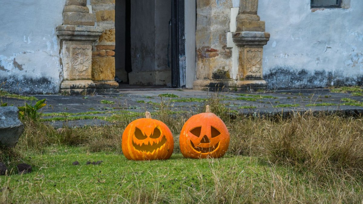 Two carved pumpkins in front of historical building in Guasca, Colombia.