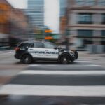 Blurry image of a police car moving quickly in an urban street showcasing motion and speed.