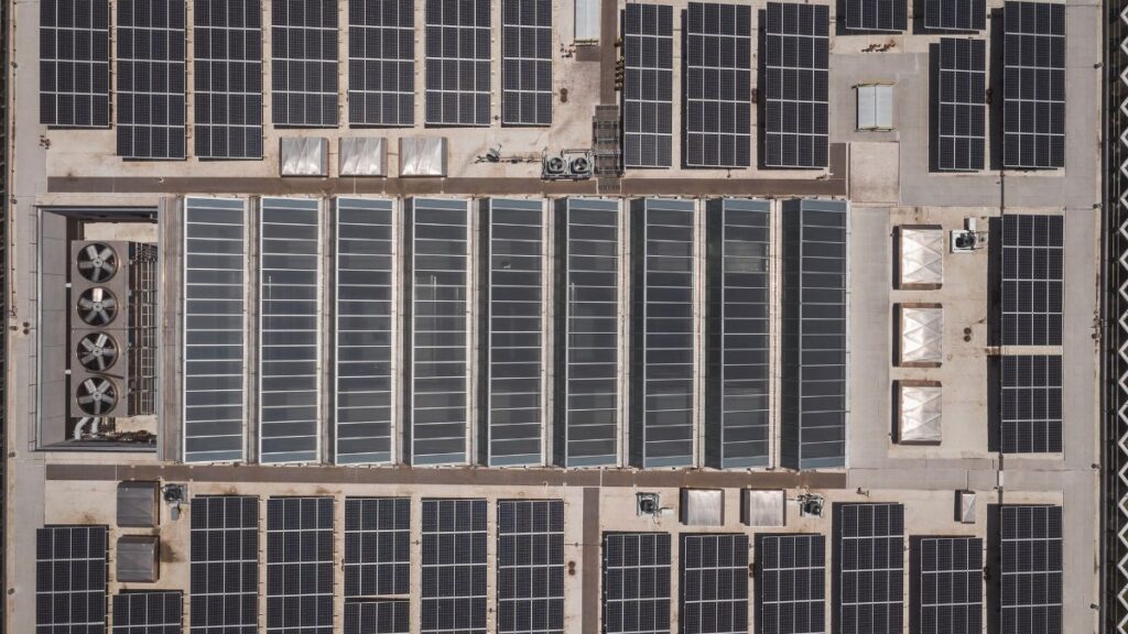 High-angle drone shot of rooftop solar panels showcasing renewable energy technology.