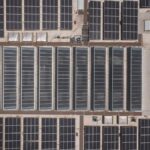 High-angle drone shot of rooftop solar panels showcasing renewable energy technology.