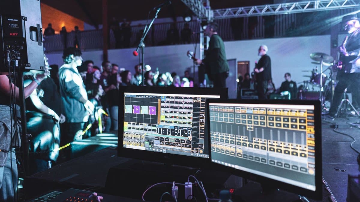 Live concert scene with sound engineering setup and band on stage.