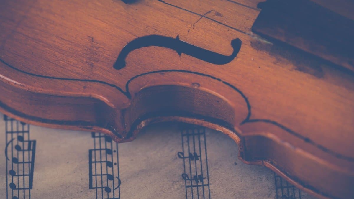 Artistic close-up of a violin on sheet music, highlighting musical elegance.