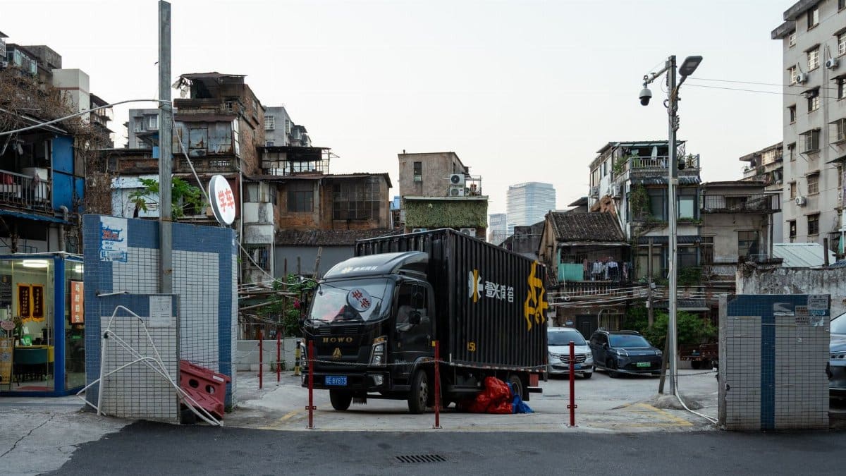 Street scene featuring a black delivery truck and surrounding urban landscape at day.