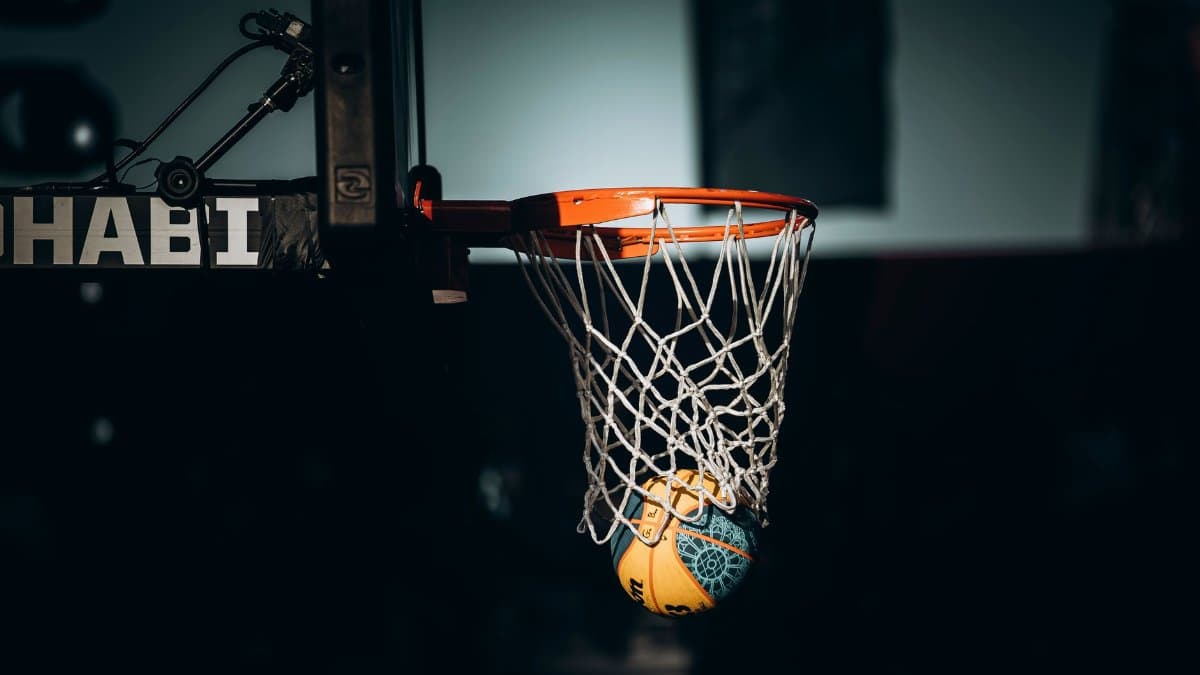 Dramatic basketball dunk captured in Abu Dhabi sports arena.