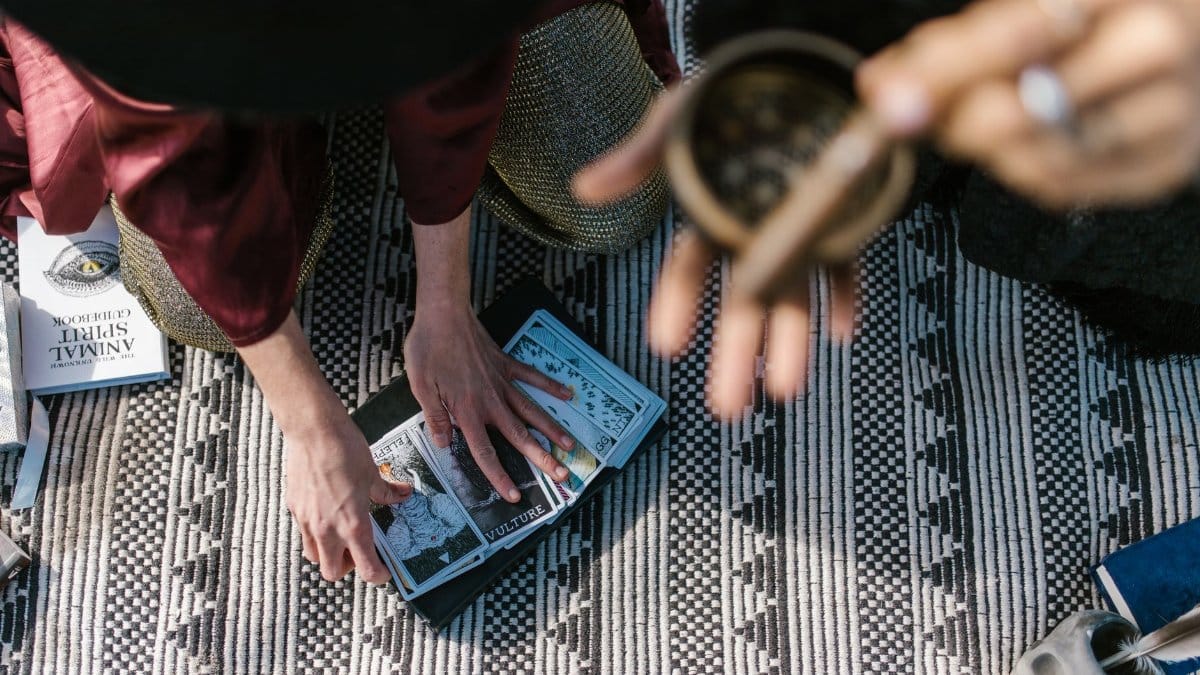 A serene setup for an intimate tarot card reading ceremony with incense and spiritual books.