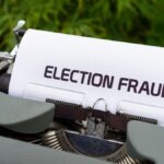 A close-up of a vintage typewriter with a paper displaying 'Election Fraud'. Ideal for themes of politics and nostalgia.