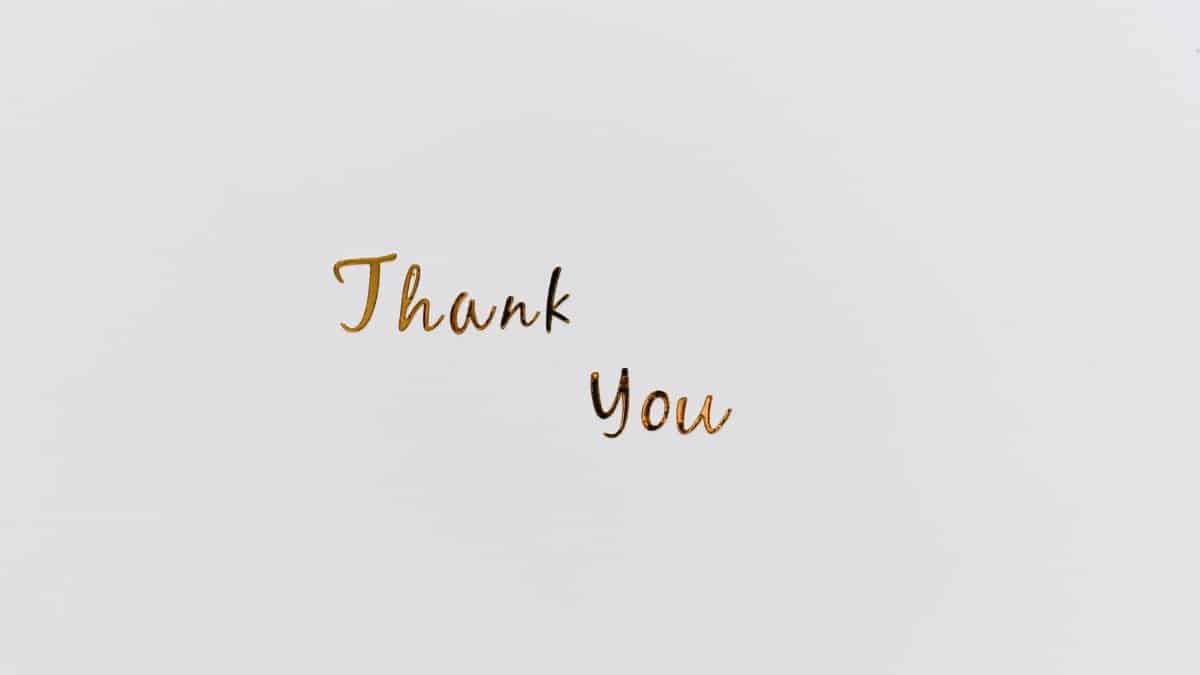 Simple and elegant gold 'Thank You' text on a clean white background, perfect for gratitude cards.