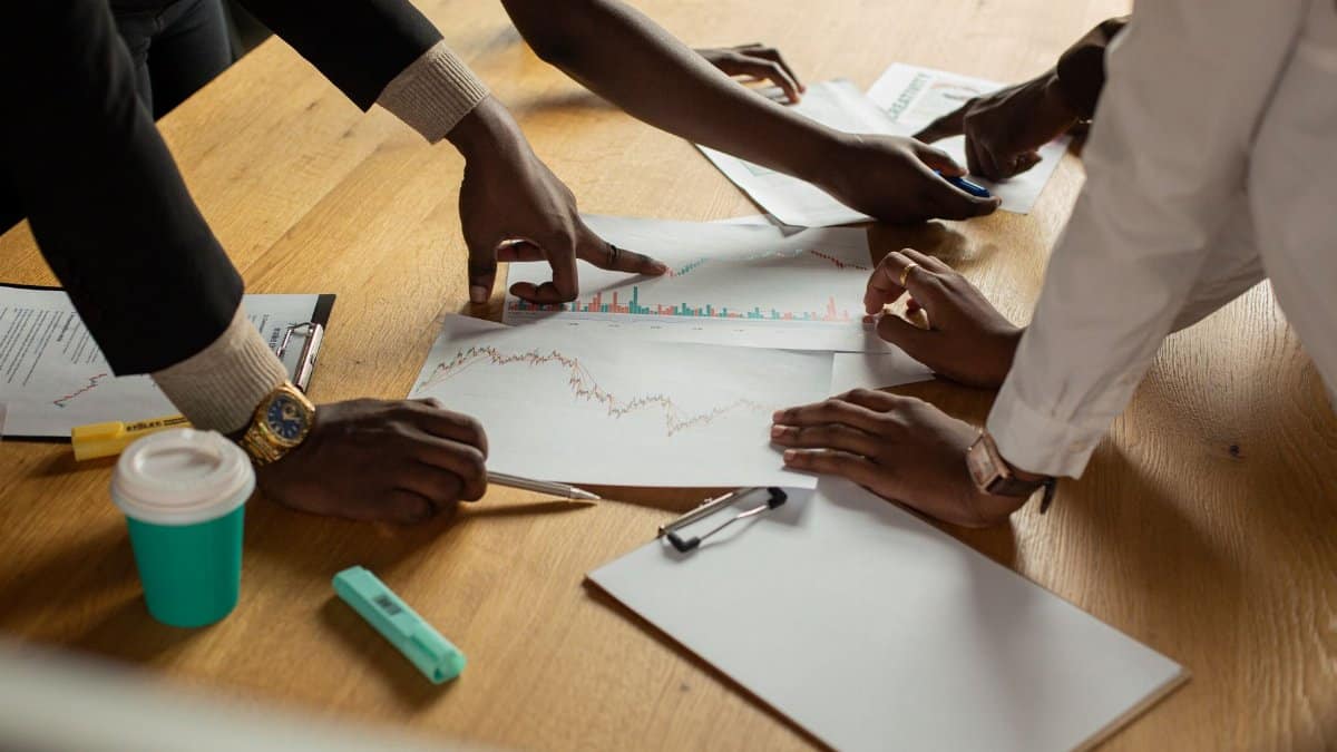 A diverse team collaborates on analyzing data charts during a meeting.