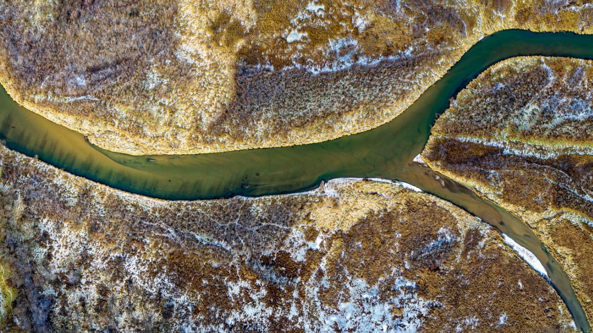 Stunning aerial shot of a meandering river surrounded by autumnal landscape in Altura, Minnesota.