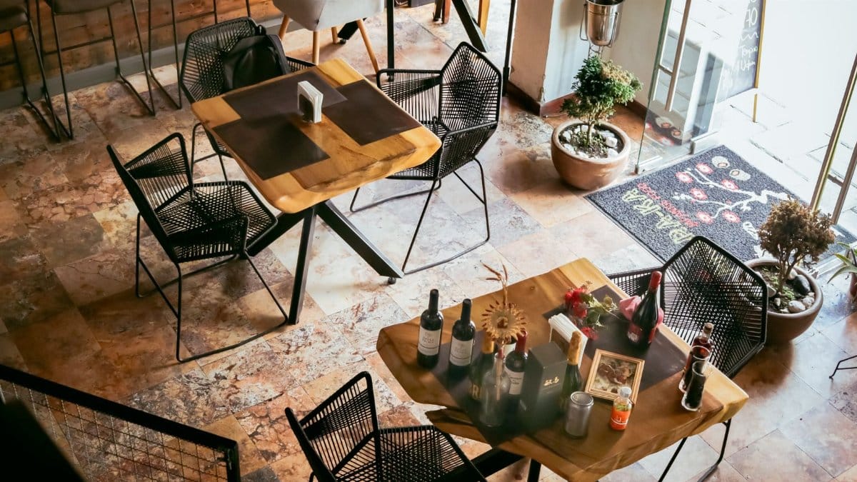 Aerial view of a rustic restaurant interior showcasing elegant table settings and warm decor.