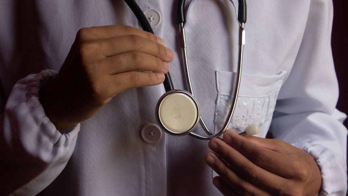 A close-up image of a doctor in a white lab coat holding a stethoscope, symbolizing healthcare.