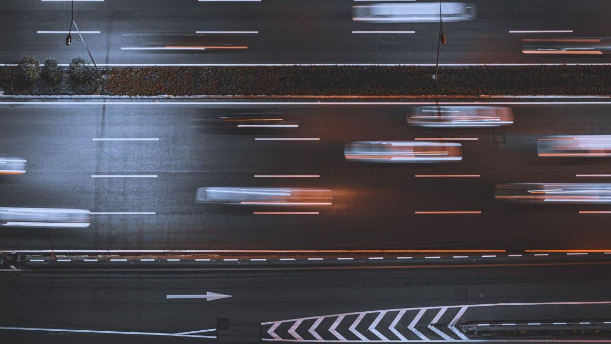 Blurred night traffic on highway, captured from above, showcasing urban speed and motion.