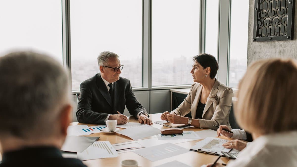 Business professionals engaged in a strategic meeting in a modern office setting with natural light.