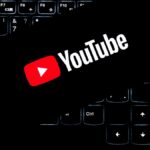 YouTube logo displayed on a backlit keyboard, representing digital media and online content creation.