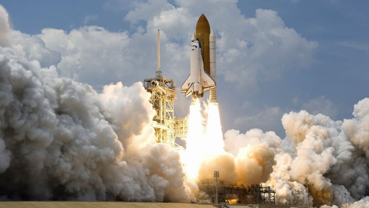Witness the powerful launch of a space shuttle amidst massive clouds of smoke against a bright sky.