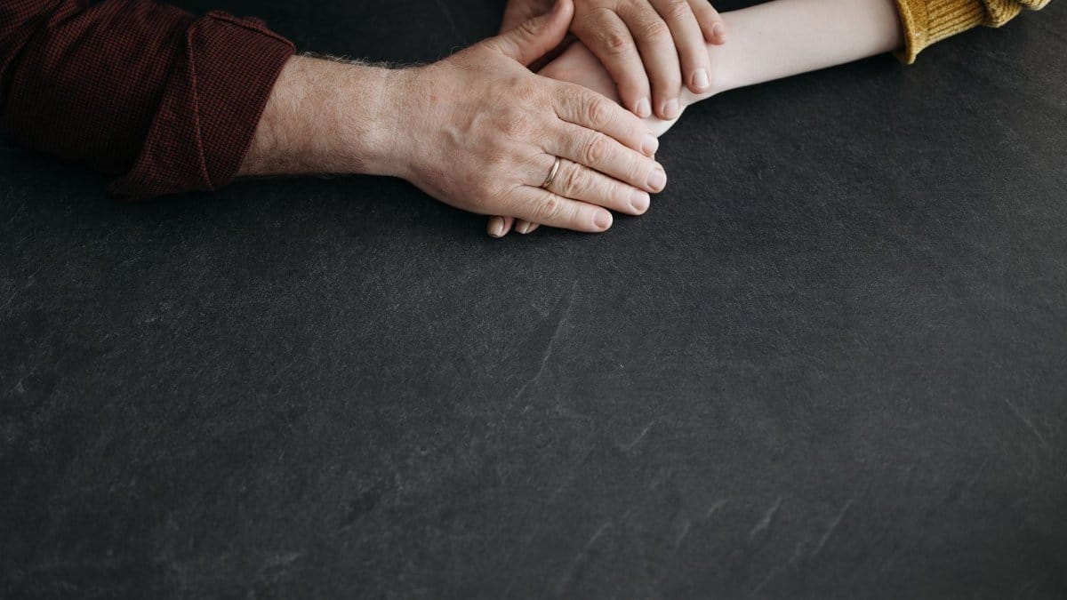 Close-up of hands showing caring touch emphasizing connection and support.